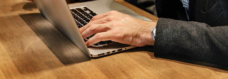 man typing on laptop